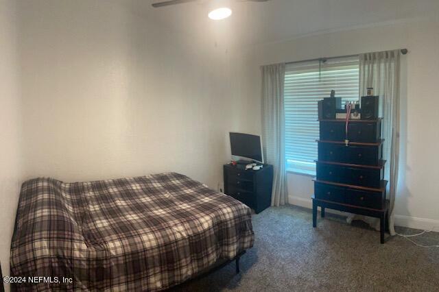 carpeted bedroom featuring ceiling fan and multiple windows