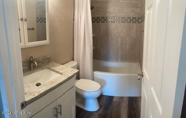 full bathroom with vanity, toilet, hardwood / wood-style flooring, and shower / tub combo