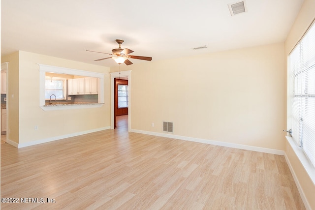 spare room featuring ceiling fan, sink, and light wood-type flooring