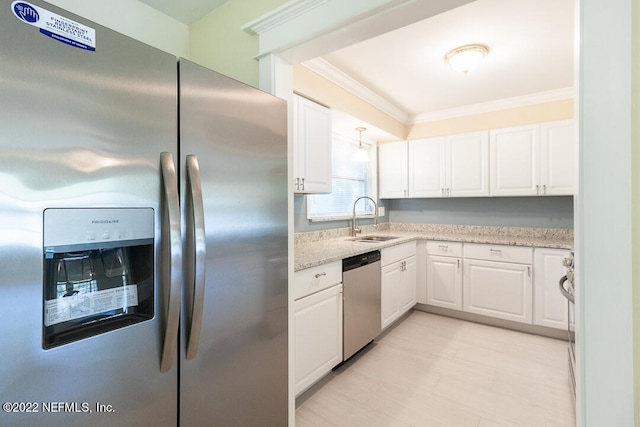 kitchen featuring light stone counters, sink, ornamental molding, white cabinetry, and appliances with stainless steel finishes