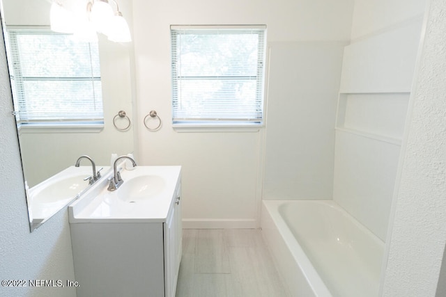 bathroom with vanity and a bath