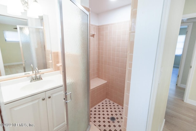 bathroom with walk in shower, wood-type flooring, and vanity