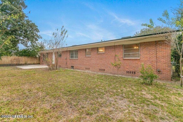 rear view of house featuring a patio area and a lawn