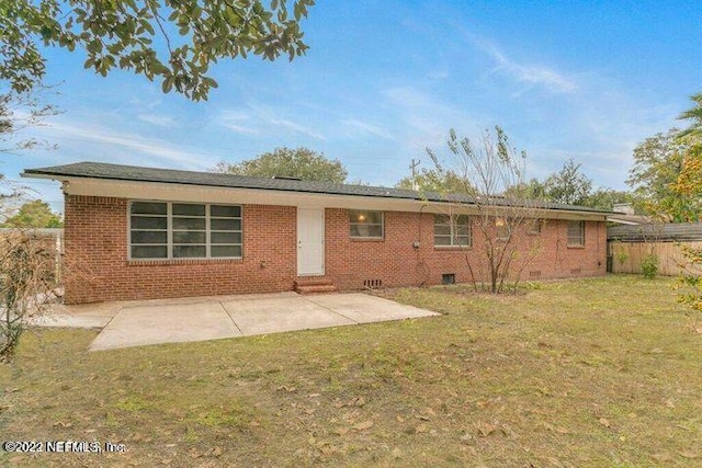 back of house featuring a lawn and a patio area