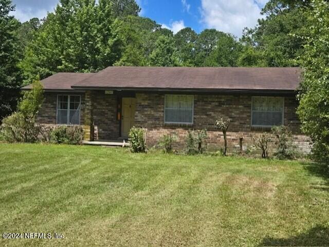 single story home featuring a front lawn