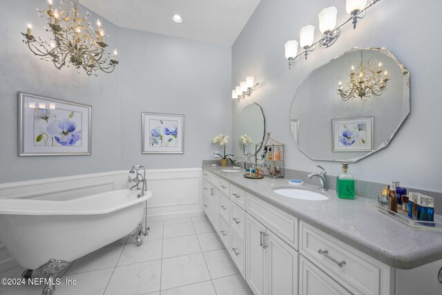 bathroom with a tub to relax in, vanity, and tile patterned floors