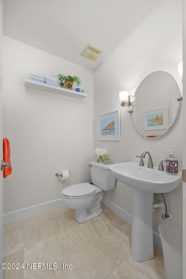 bathroom with toilet and tile patterned flooring