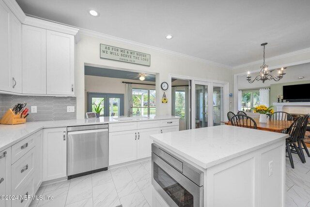 kitchen with french doors, stainless steel appliances, white cabinets, tasteful backsplash, and crown molding