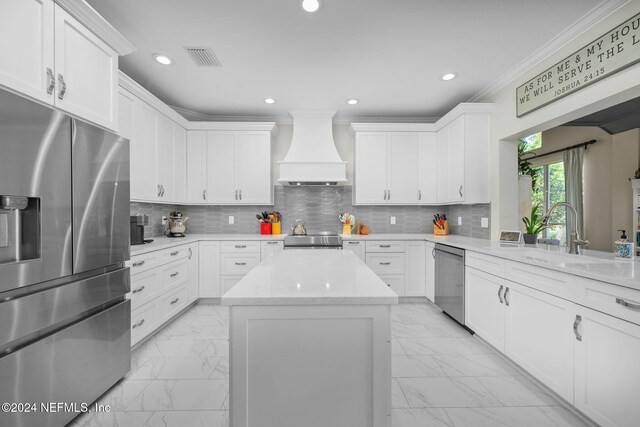 kitchen with white cabinets, custom range hood, stainless steel appliances, and sink