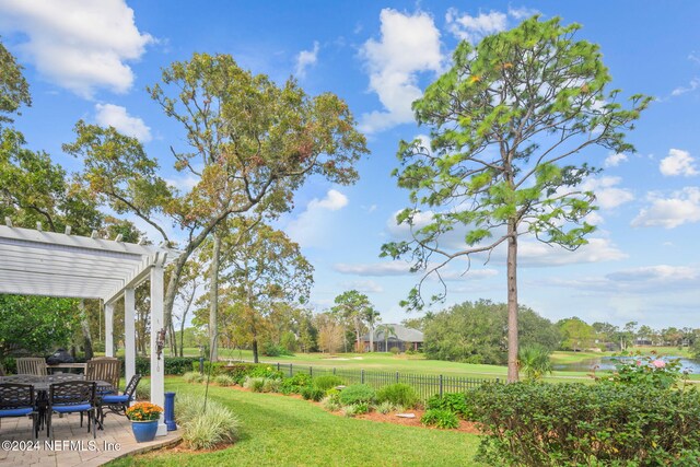 view of yard featuring a patio area, a pergola, and a water view