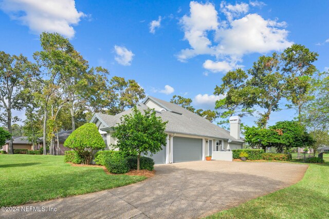 view of front of property featuring a garage and a front lawn