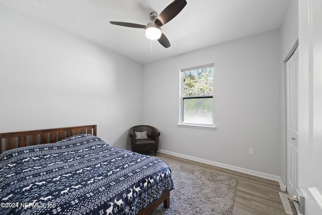 bedroom with ceiling fan, a closet, a textured ceiling, and hardwood / wood-style flooring