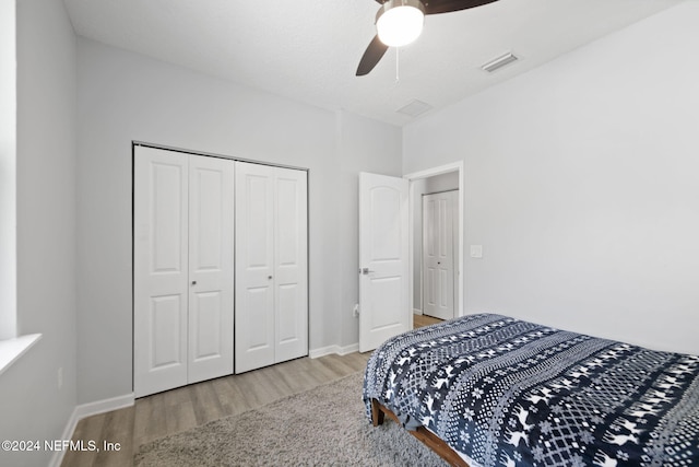 bedroom featuring hardwood / wood-style flooring, ceiling fan, and a closet