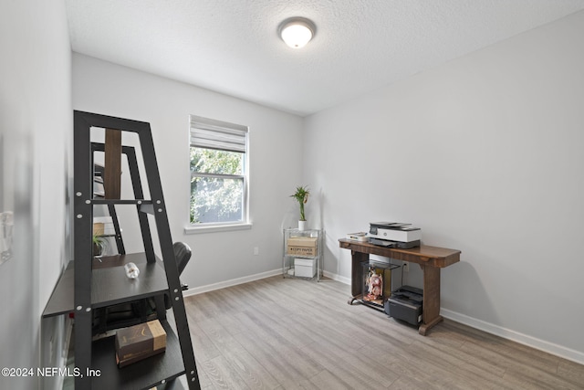 home office featuring wood-type flooring and a textured ceiling