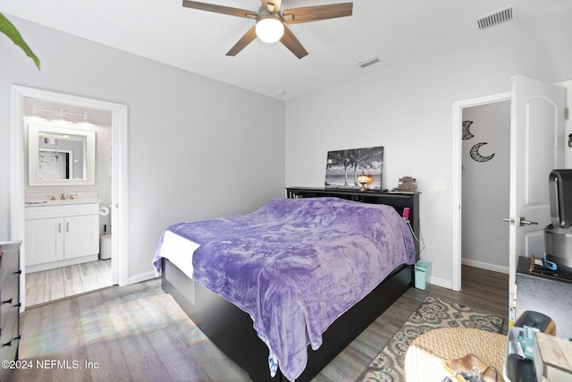 bedroom with sink, ceiling fan, dark hardwood / wood-style flooring, and ensuite bathroom