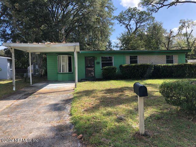 single story home with a front lawn and a carport