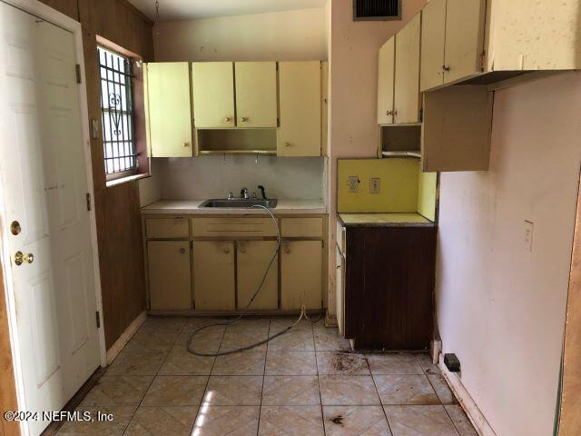 kitchen featuring cream cabinets, sink, and light tile patterned floors