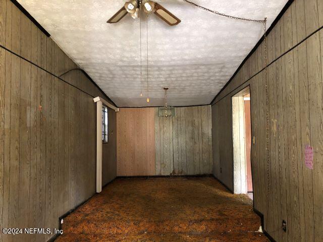 spare room with wooden walls and ceiling fan