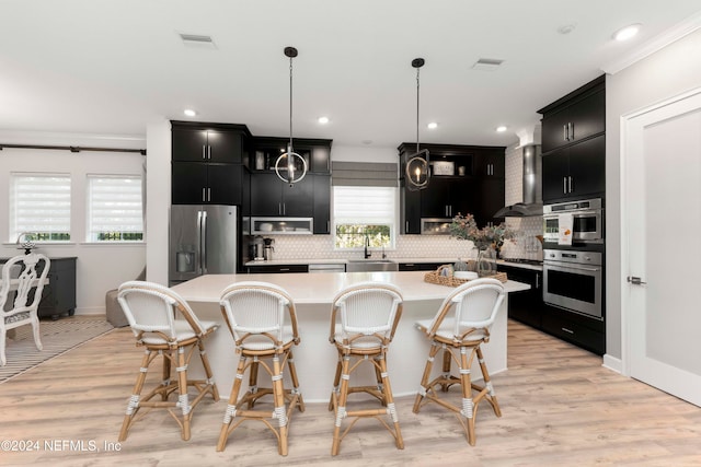 kitchen featuring a wealth of natural light, decorative light fixtures, appliances with stainless steel finishes, and a center island