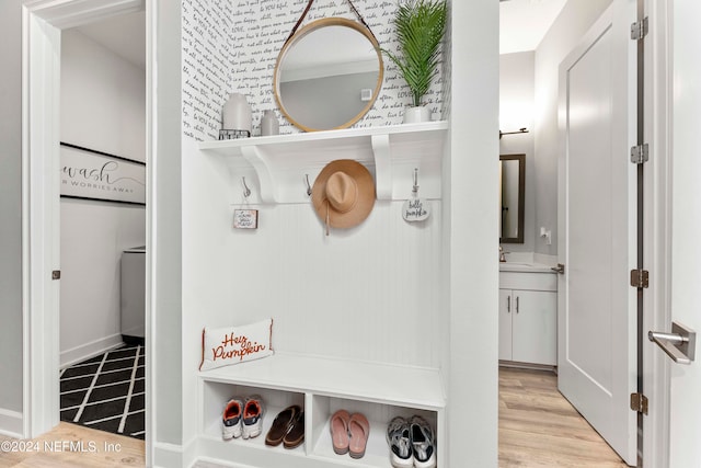 mudroom with sink and light hardwood / wood-style flooring