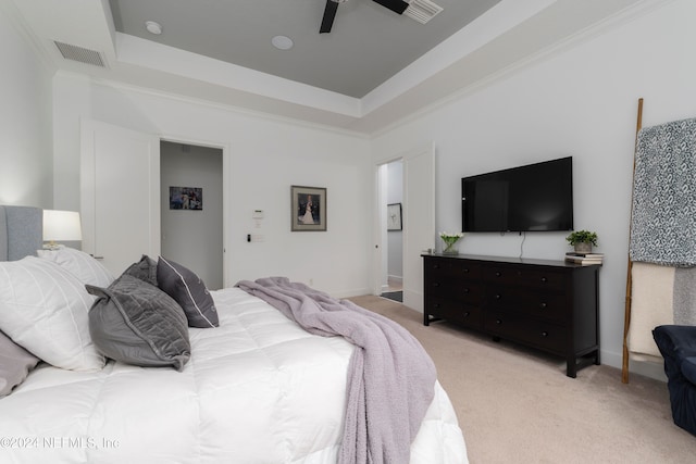 bedroom featuring ceiling fan, a raised ceiling, crown molding, and light colored carpet