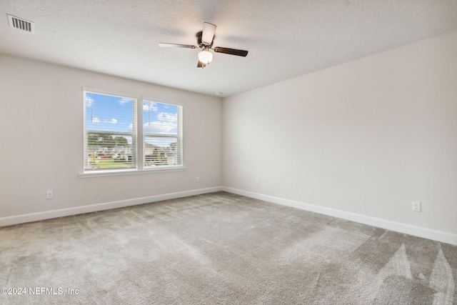 carpeted empty room featuring a textured ceiling and ceiling fan