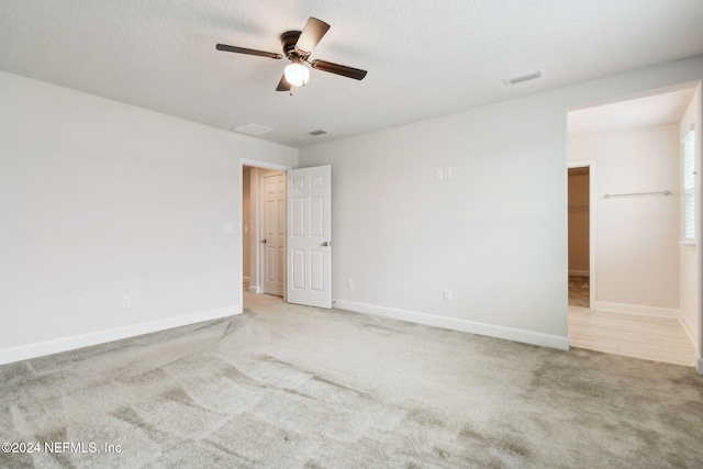 unfurnished room featuring ceiling fan and light colored carpet