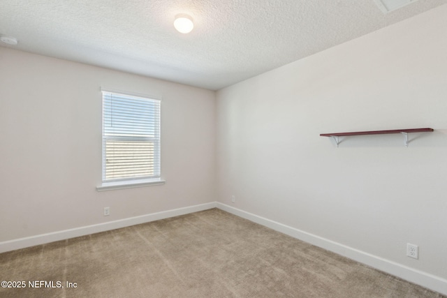 carpeted empty room featuring a textured ceiling