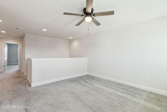 unfurnished room with a textured ceiling, light colored carpet, and ceiling fan