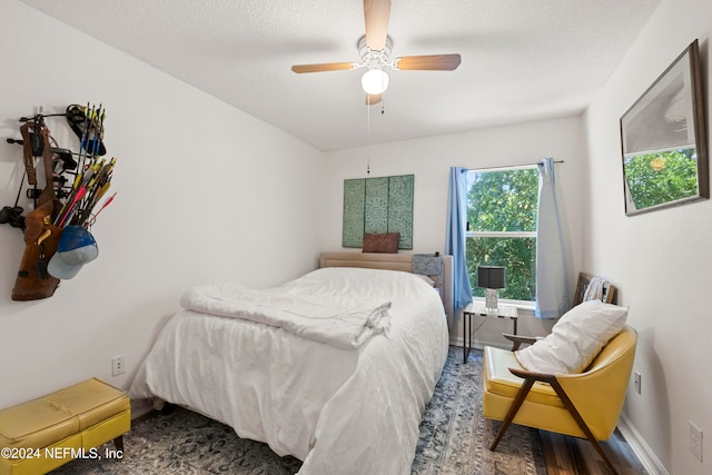 bedroom featuring hardwood / wood-style floors, a textured ceiling, and ceiling fan