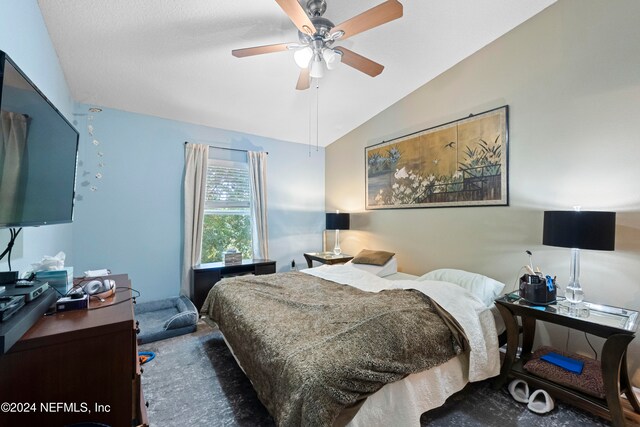 carpeted bedroom featuring ceiling fan, a textured ceiling, and lofted ceiling