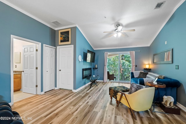 sitting room with lofted ceiling, crown molding, light wood-type flooring, and ceiling fan