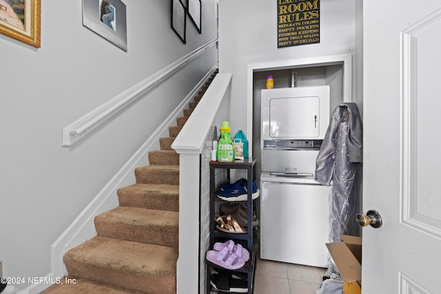 laundry room featuring stacked washer / drying machine and light tile patterned floors