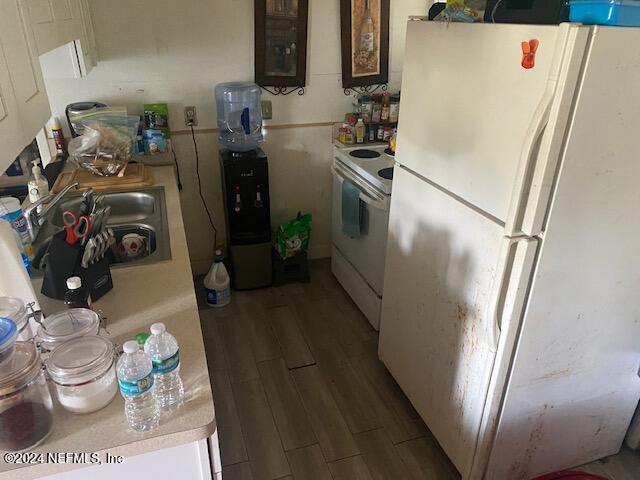 kitchen with dark hardwood / wood-style floors, sink, and white appliances