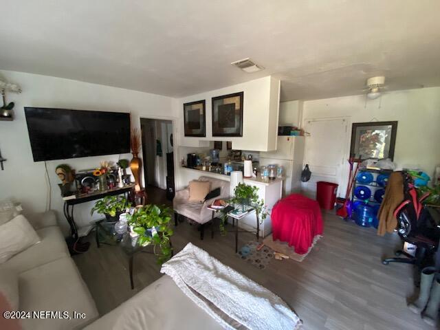 living room featuring wood-type flooring and ceiling fan