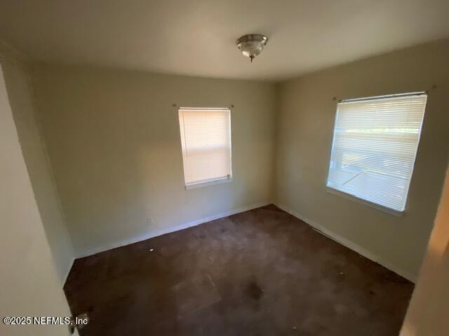 spare room with baseboards