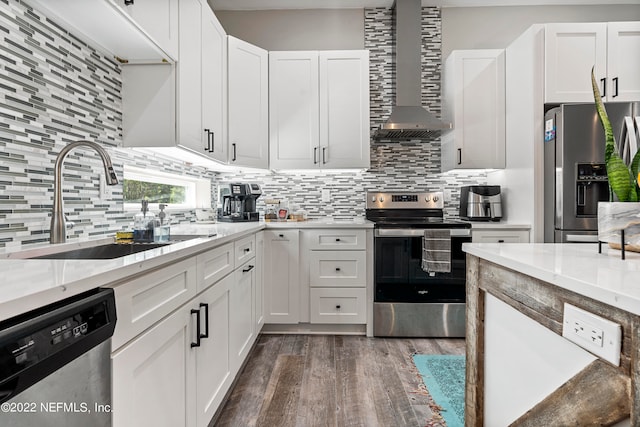 kitchen featuring white cabinets, decorative backsplash, wall chimney exhaust hood, dark hardwood / wood-style floors, and appliances with stainless steel finishes