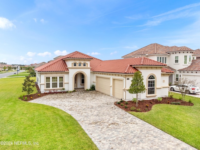 mediterranean / spanish-style house with a front lawn and a garage