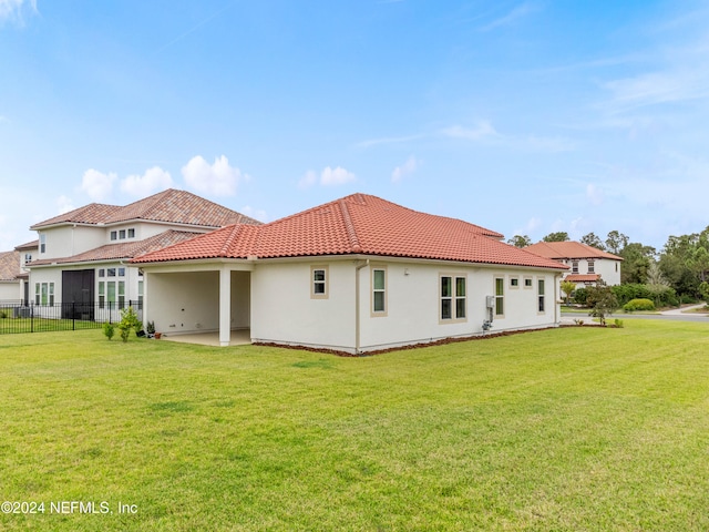 back of property featuring a lawn and a patio area