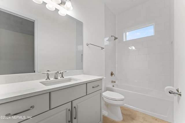 full bathroom featuring tile patterned flooring, vanity, tiled shower / bath combo, and toilet