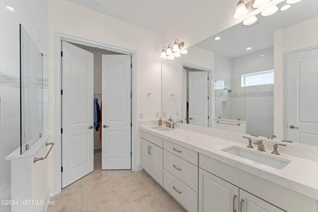 bathroom featuring tiled shower, vanity, and tile patterned floors