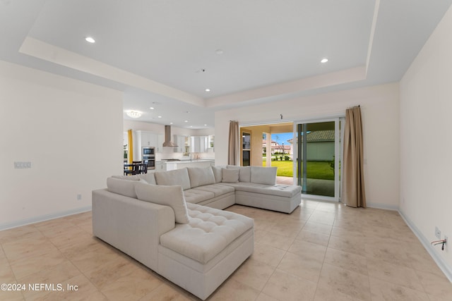 tiled living room featuring a tray ceiling