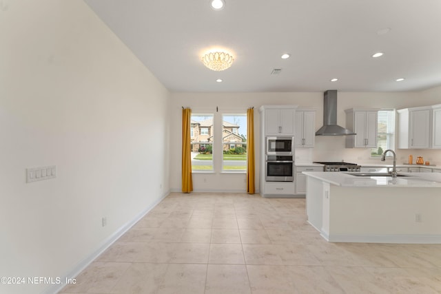 kitchen with white cabinets, sink, wall chimney exhaust hood, and stainless steel appliances