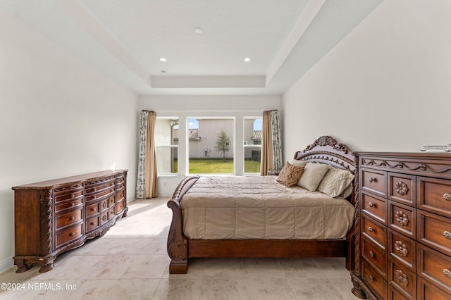 tiled bedroom featuring a raised ceiling