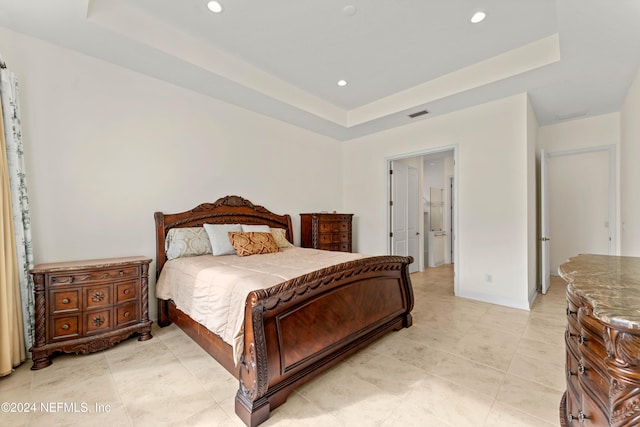 bedroom featuring a tray ceiling and light tile patterned flooring