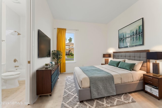 bedroom featuring light wood-type flooring and connected bathroom