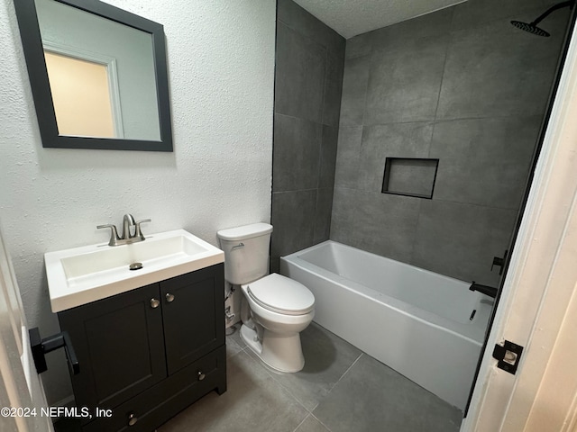 full bathroom with a textured ceiling, vanity, tile patterned floors, toilet, and tiled shower / bath combo