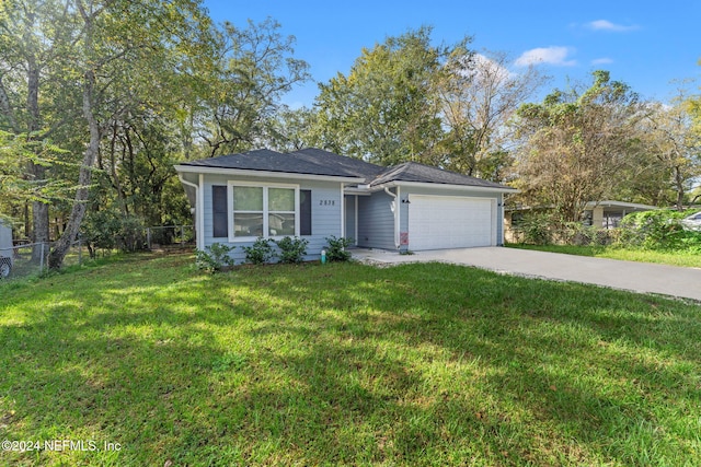 ranch-style house featuring a garage and a front lawn