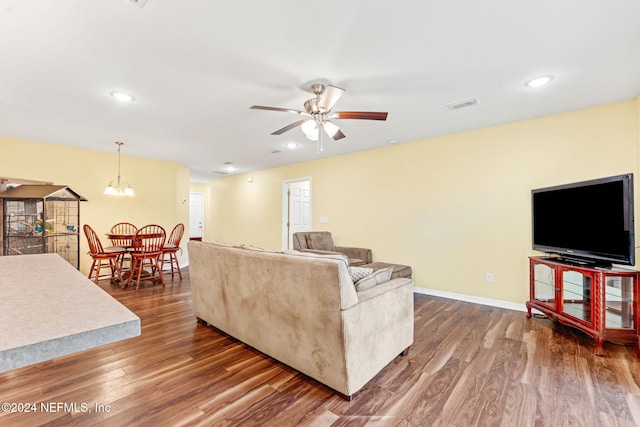 living room featuring hardwood / wood-style flooring and ceiling fan with notable chandelier