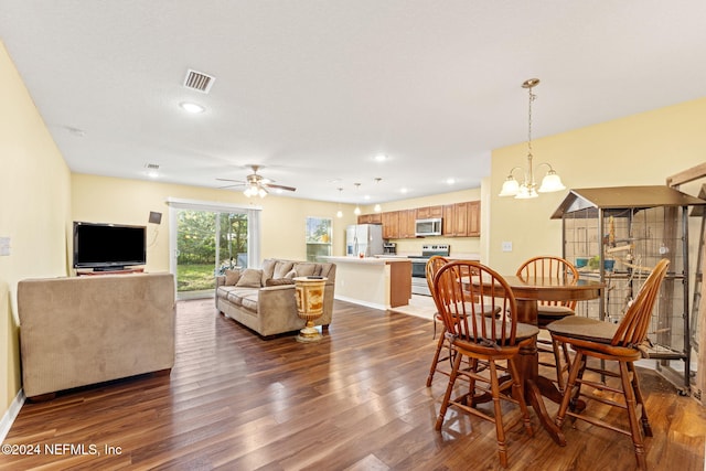 dining area with dark hardwood / wood-style flooring and ceiling fan with notable chandelier